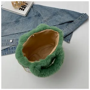 Detail view of green faux fur bag with magnetic clasp, metal chain, and beige lining