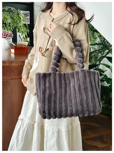 Détail du sac cabas en peluche grise à texture côtelée et poignée à pompons