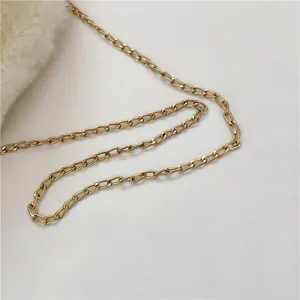 Detail of soft white faux fur texture and golden metal chain strap on a plush bucket bag