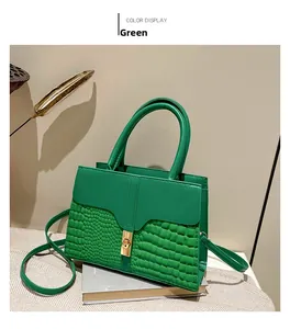 Details der grünen Handtasche mit Kroko-Struktur und goldenem Drehverschluss