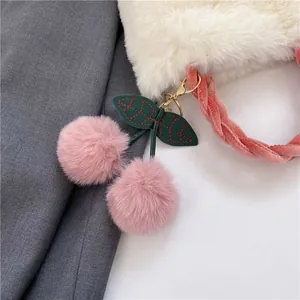 Close-up of fluffy white faux fur texture with pink velvet braided handle and cherry charm