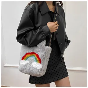 Detail of grey plush faux fur handbag with colorful rainbow embroidery and gold chain