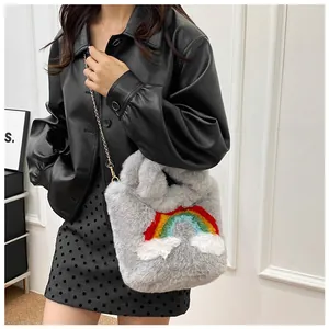 Detailed close-up of a grey plush shoulder bag featuring rainbow embroidery and gold chain