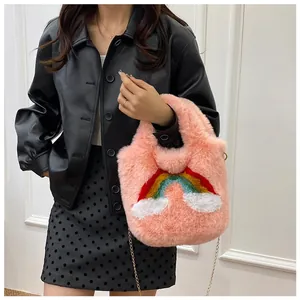 Pink plush tote bag detail with rainbow and cloud embroidery and gold chain strap