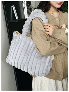 Détail du sac cabas en peluche grise avec texture rayée et poignée à pompon doux