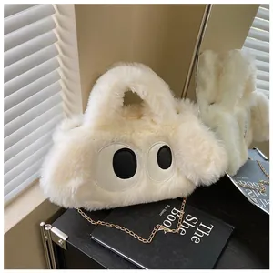 Détail du sac en peluche avec grands yeux, poignée douce et bandoulière chaîne dorée