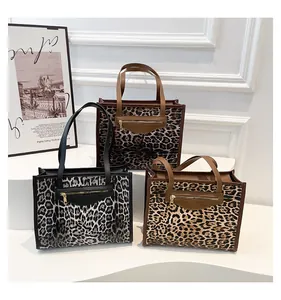 Detailed view of leopard print tote bags in brown and grey with front zipper accents