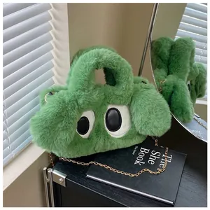 Détail du sac à main en peluche verte avec yeux de dessin animé et fine chaîne dorée