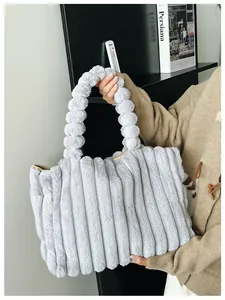 Détail du sac cabas en peluche gris clair avec texture plissée et bandoulière à boules