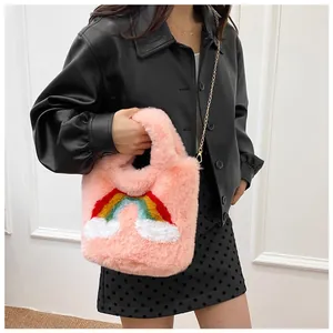 Detail of pink faux fur handbag featuring rainbow cloud patch and gold chain strap