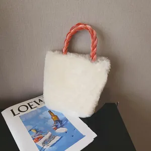 Detail of plush white handbag showing soft faux fur and orange velvet knotted handle