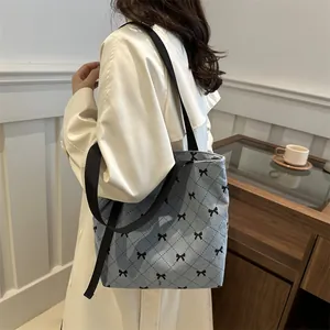 Schultertasche aus blauem Cord mit schwarzem Schleifendruck und breitem Trageriemen