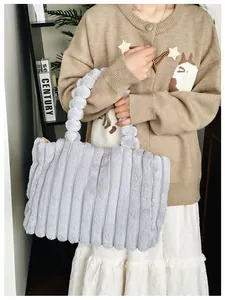 Détails du sac cabas en peluche gris clair avec rayures et poignée à pompons