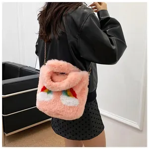 Detail of pink faux fur plush handbag with rainbow embroidery and gold chain strap
