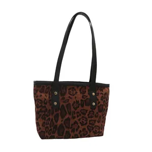 Fashionable leopard print tote bag with black leather straps and gold metal studs