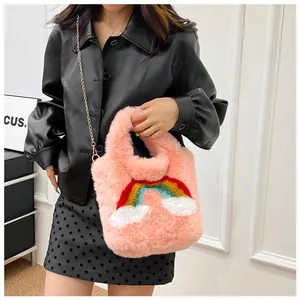 Detail of pink plush handbag with rainbow embroidery and elegant golden chain strap