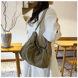 Detail of olive green nylon hobo bag with side drawstring and adjustable strap