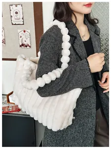 Détail du sac cabas en peluche crème avec bandoulières à bulles et texture à rayures