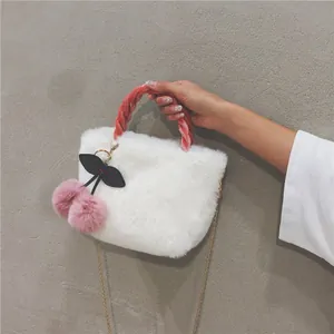 Detail of white faux fur handbag featuring pink velvet woven handle and golden chain strap