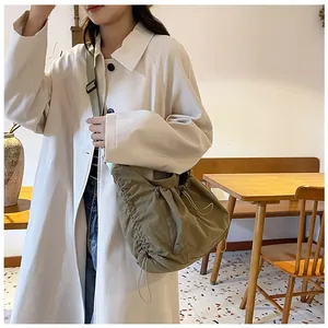 Detail of khaki nylon pleated dumpling bag with drawstring and wide shoulder strap