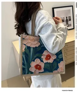 Gros plan détaillé d'un sac cabas en lin avec motifs floraux roses en relief 3D sur bleu