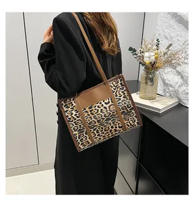 Detail of vintage leopard print tote with brown leather trim and metallic buckle closure