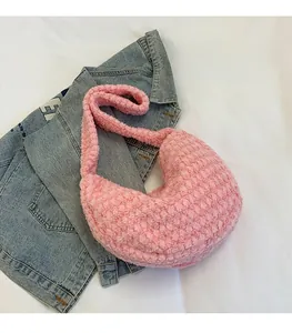 Close-up of pink fuzzy teddy fur tote bag on denim, showing soft textured fabric detail