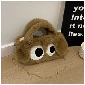 Gros plan du sac en peluche marron avec de grands yeux et une fine bandoulière dorée