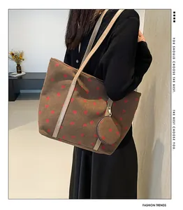Detail of strawberry corduroy tote bag with small matching round purse and leather straps