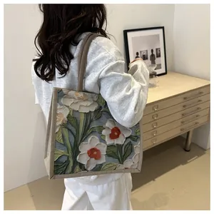 Vue détaillée du gaufrage floral en 3D sur ce grand sac cabas en lin pour femme