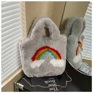 Detail of grey plush tote bag with rainbow and cloud applique on a black book prop