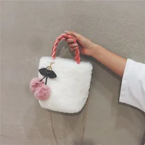 Detail of white faux fur handbag with pink velvet handle and cherry charm decoration