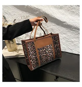 Detail of leopard print tote bag with brown leather handles and chic vintage texture