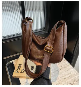 Détail du sac dumpling marron foncé avec texture vintage et logo doré chic
