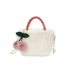 Plush faux fur crossbody bucket bag with pink woven handle and cherry charm detail