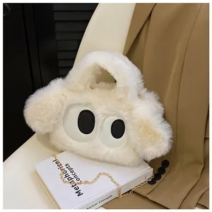 Détail du sac à main en peluche crème avec yeux de dessin animé et chaîne dorée