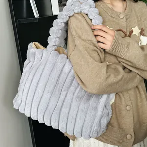 Sac fourre-tout gris clair en fausse fourrure avec poignée pompon et texture côtelée