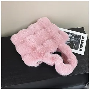 Nahaufnahme einer rosa Plüsch-Handtasche mit gesteppter Textur und Pelzgriff