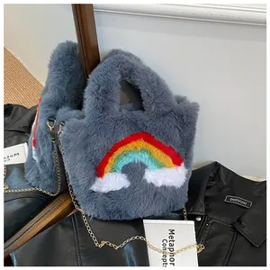 Detail of gray plush handbag featuring rainbow embroidery and gold metal chain strap
