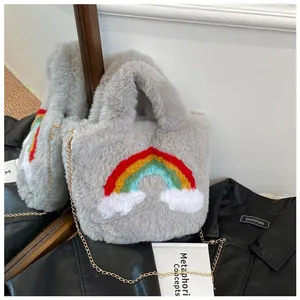 Detail of grey plush handbag featuring colorful rainbow embroidery and gold chain strap