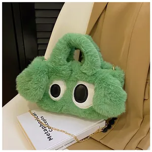 Détail du sac à main en peluche verte avec grands yeux rigolos et chaîne dorée