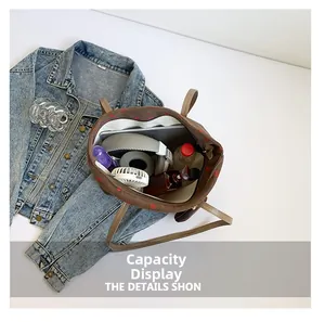 Capacity display of large brown corduroy tote bag showing interior storage for electronics