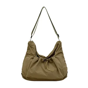 Chic khaki nylon dumpling shoulder bag with adjustable strap and front drawstring pocket