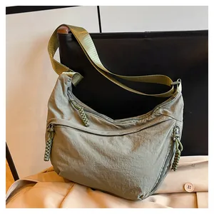 Détail du sac bandoulière en nylon vert armée avec tirettes tressées et sangle réglable