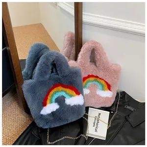Close-up of grey and pink plush handbags with rainbow patches and metal chain straps