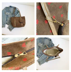 Detail view of brown corduroy tote bag with strawberry print and small matching pouch