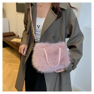 Detail einer weichen rosa Plüschtasche mit goldenen Beschlägen und Lederriemen