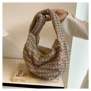 Close-up of soft beige faux fur pleated tote bag with smooth zipper detail for autumn