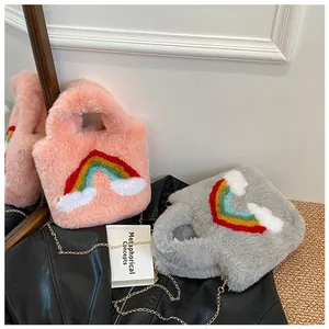 Detail of plush faux fur bags with rainbow embroidery and golden metal chain straps