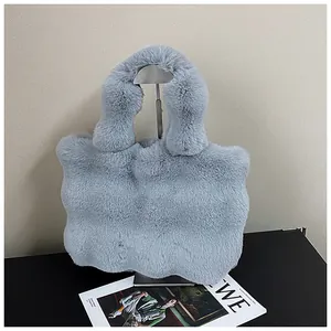 Detailansicht einer weichen, graublauen Plüsch-Handtasche mit flauschigem Webpelz-Griff